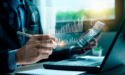 a person using a laptop and a pen